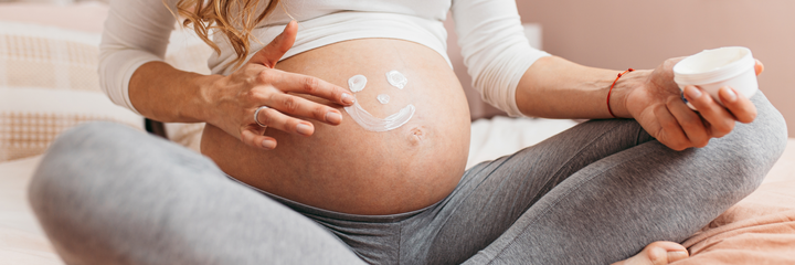 Lächelnder Smiley auf dem Bauch einer schwangeren Frau